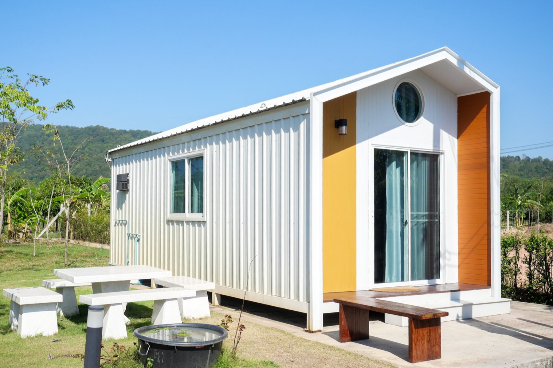 Knock Down Villa exterior with white cladding and yellow-orange accent