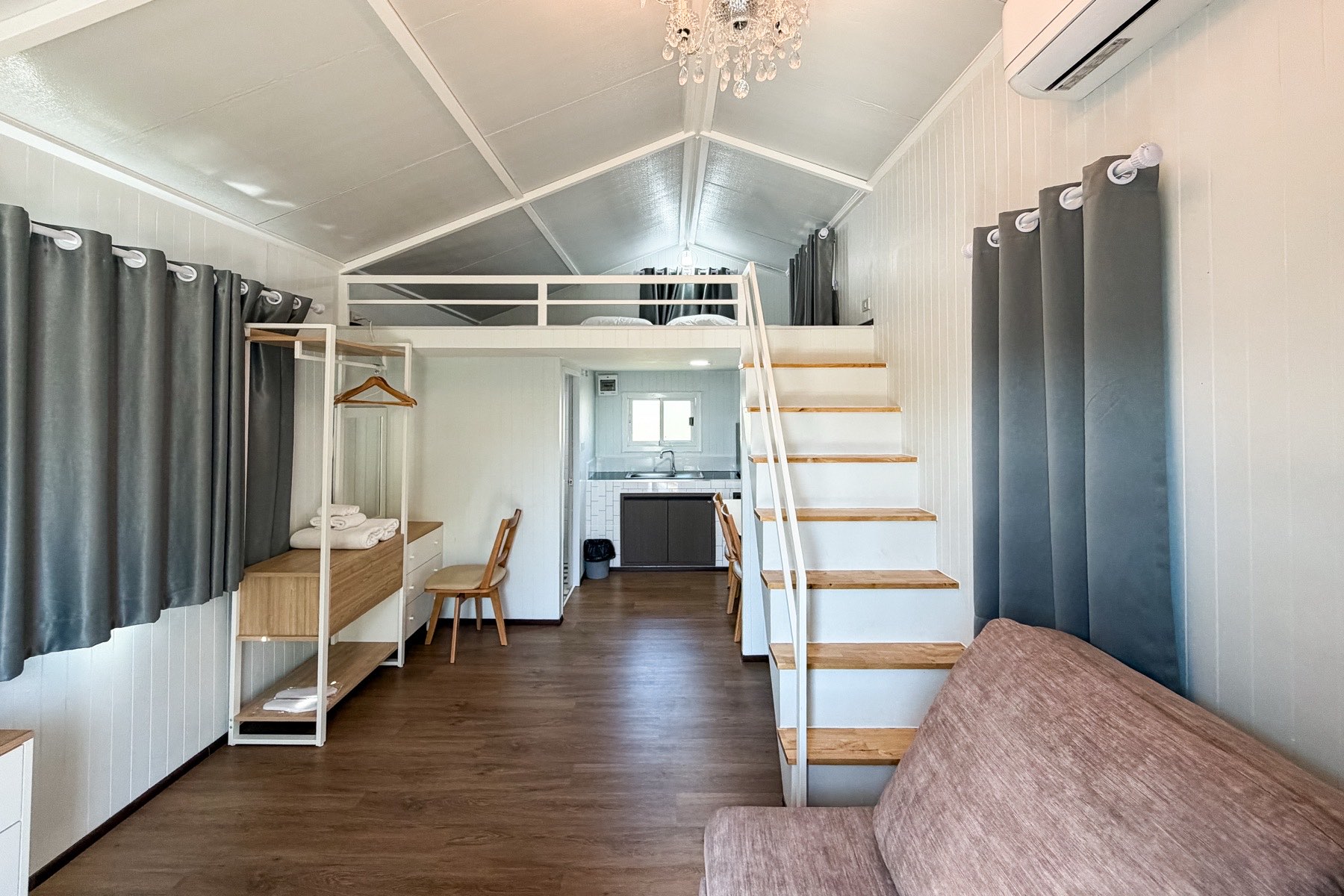Knock Down Villa loft interior with staircase and sofa