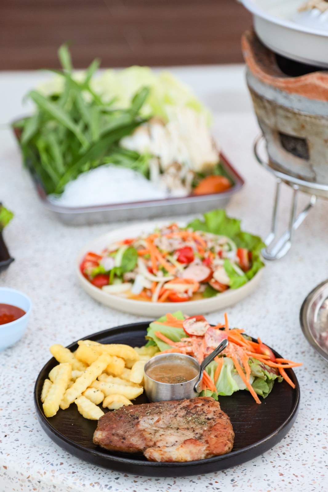 Moo Kata Thai BBQ hot pot with grilled meats, som tam, and sides