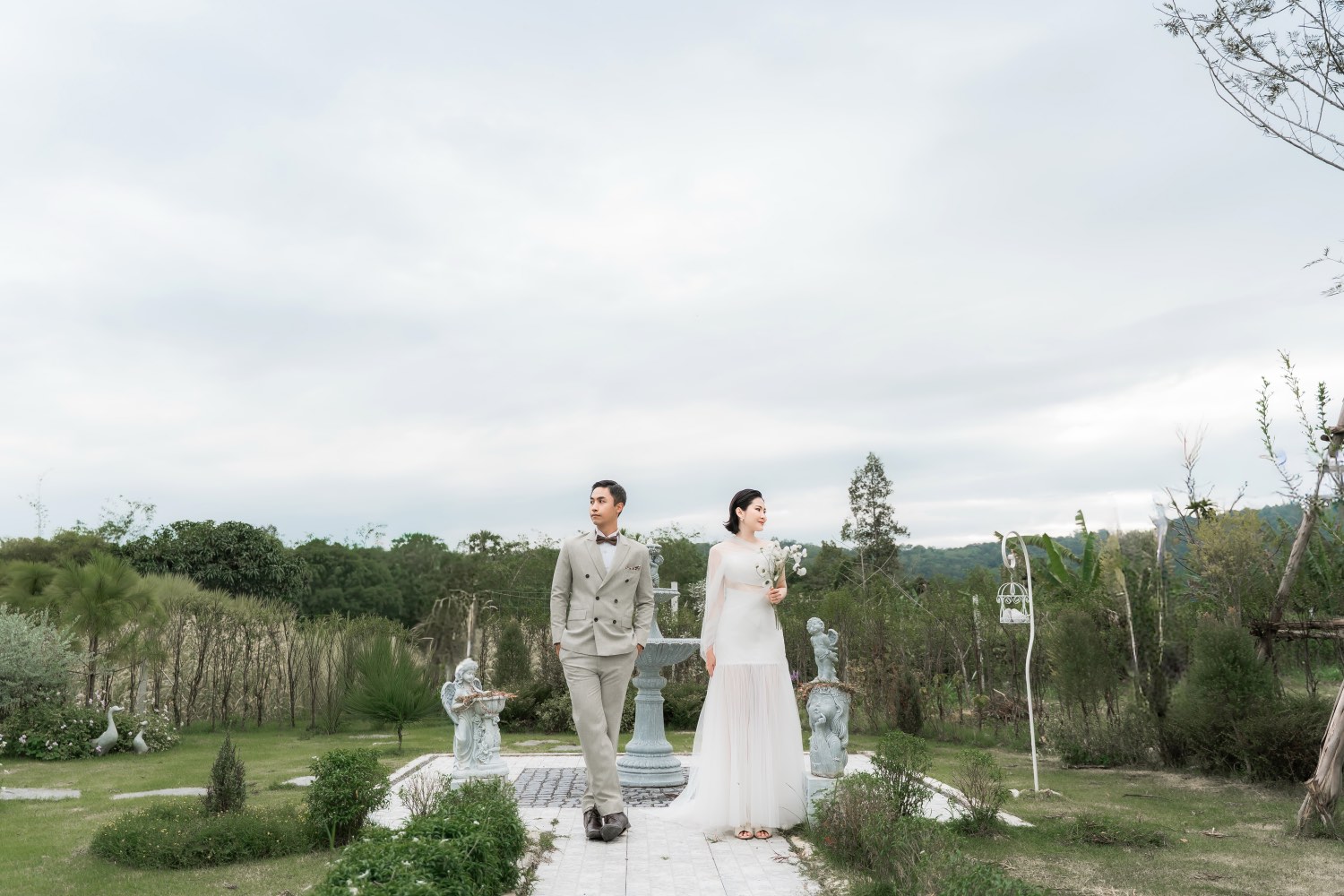 Wedding couple in the garden by a fountain
