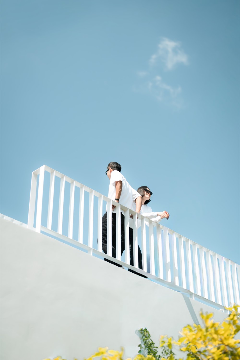 Wedding couple on a white balcony against a clear blue sky